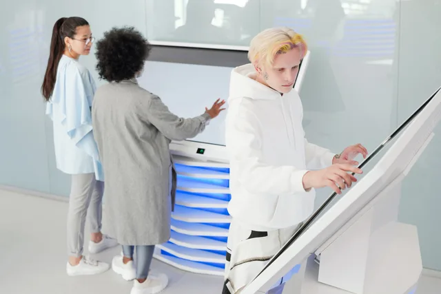 Diverse group interacting with large futuristic touchscreens in a modern tech environment. Införandeplan för nytt system: övergång, utbildning och drift